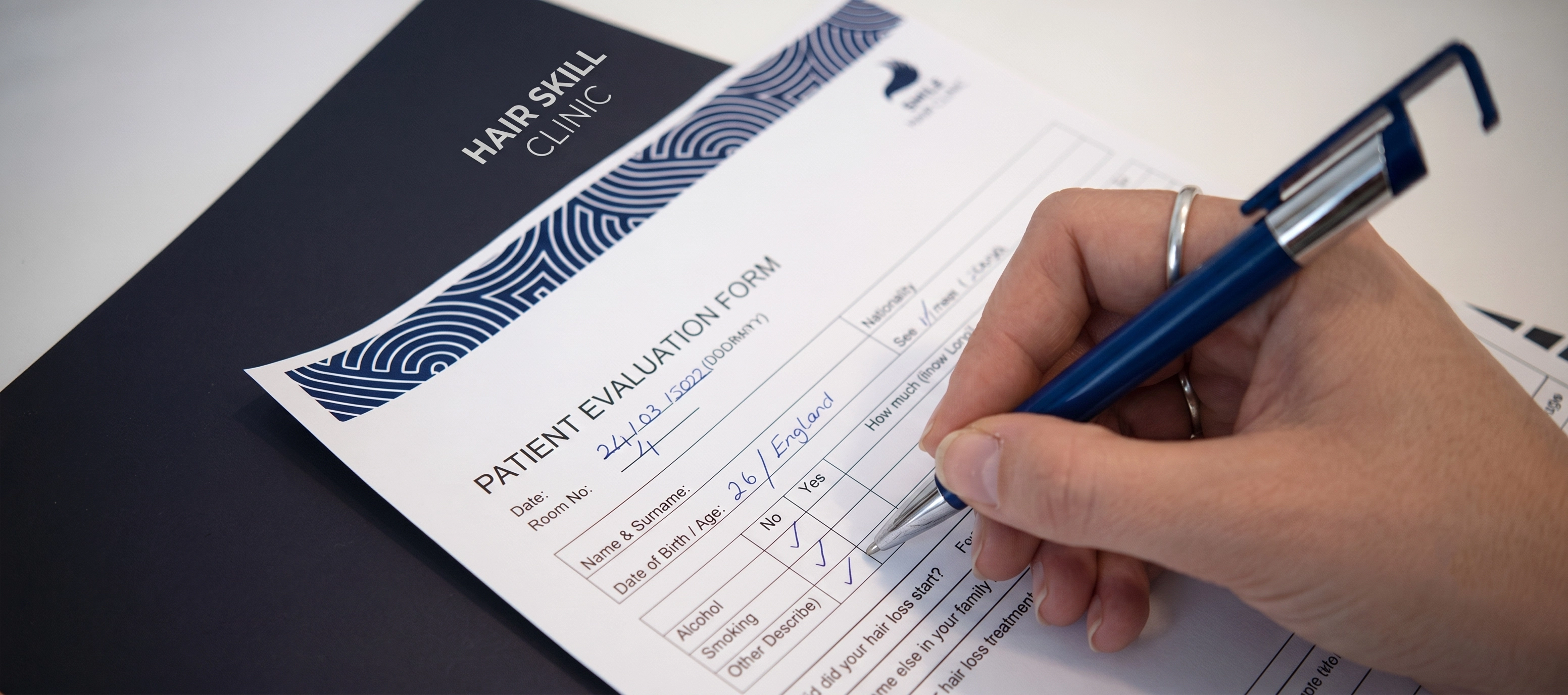 Patient completing medical evaluation form at Hair Skill Clinic